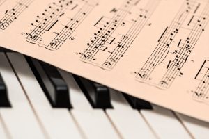 Foto van bladmuziek liggende op de toetsen van een piano